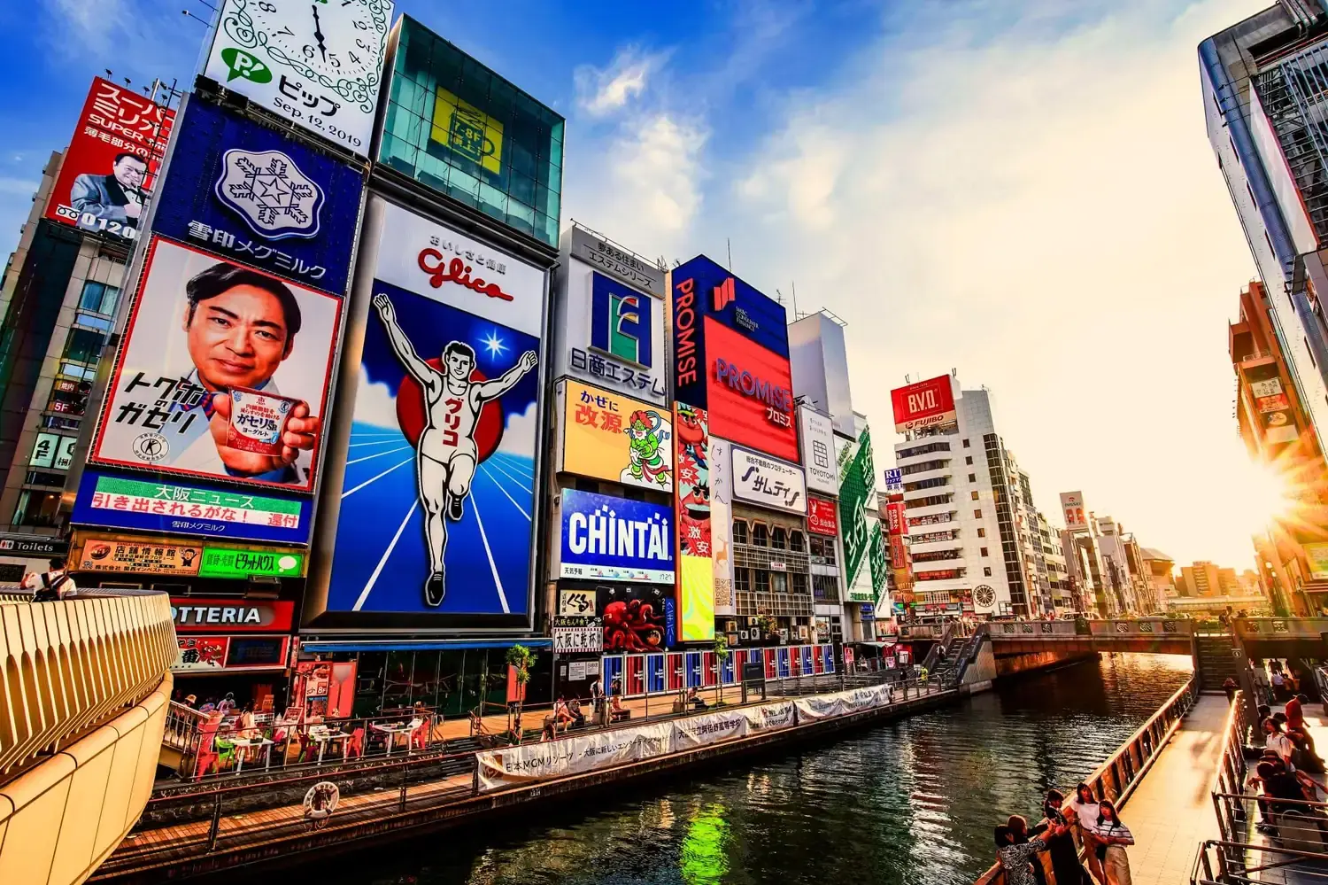 Dotonbori canal with the iconic Glico sign and neon billboards above the Osaka river — stop on a private Osaka city tour